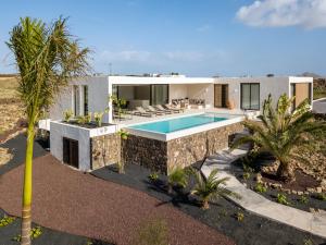 a villa with a swimming pool in the desert at Villa Gara exclusive luxury villa with heated pool in Lajares