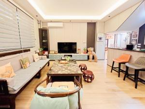 a living room with a couch and a table at Kinmen Life With Bird Homestay- Near Kinmen Airport in Jinhu