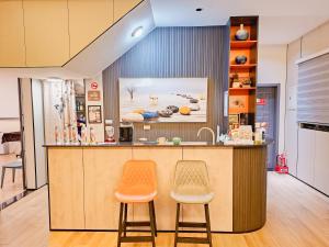 a kitchen with two orange stools at a counter at Kinmen Life With Bird Homestay- Near Kinmen Airport in Jinhu