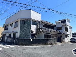 a white house on the side of a street at 勝浦の家 in Katsuura +6 photos