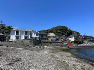 a group of houses on a beach next to the water at 勝浦の家 in Katsuura
