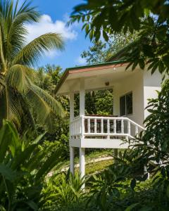 a white house with a porch in the jungle at Zen Village in Ko Phangan