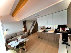 a kitchen and living room with a table and a couch at Elite Gerlach Mezonet in Svätý Jur