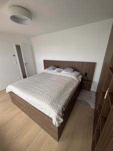 a bedroom with a large bed with a wooden headboard at Elite Gerlach Mezonet in Svätý Jur +23 photos