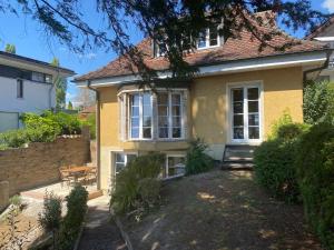 a yellow house with a bench in front of it at Villa Art Residence Überlingen in Überlingen