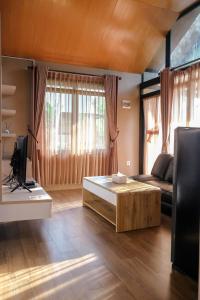 a living room with a couch and a coffee table at Teras Bumi Cabin in Haurkuning
