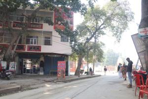 a street with a building and people walking down the street at Shri Ram seva sadan in Vrindāvan