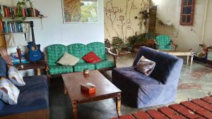 a living room with two couches and a table at Home Sol Guesthouse in Pantai Cenang
