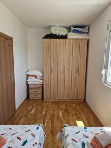 a bedroom with a bed and a wooden cabinet at Vuković house - Lake View & Nature in Kuside +41 photos