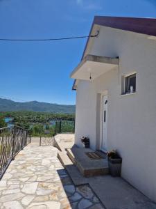 a white building with a door and a balcony at Vuković house - Lake View & Nature in Kuside