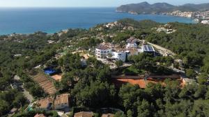 an aerial view of a house on a hill next to the ocean at Hilton Mallorca Galatzo in Paguera
