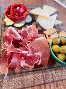 a cutting board with meat and cheese and other foods at Lumae Guesthouse in Lobres