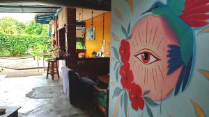 a room with a wall with a painting of an eye at Home Sol Guesthouse in Pantai Cenang