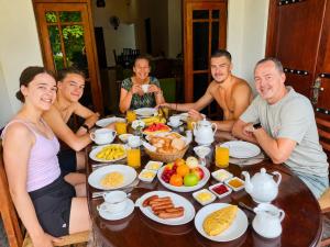 a group of people sitting around a table with food at Glory Rajarata Lakeside Resort in Anuradhapura