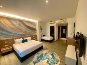 a bedroom with two beds and a large painting on the wall at Corner Club Penang in George Town