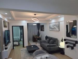 a living room with a couch and a tv at Smart Cloud Apartment in Nairobi