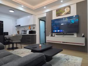 a living room with a large flat screen tv on a wall at Smart Cloud Apartment in Nairobi