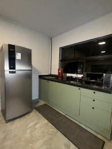 an empty kitchen with a stainless steel refrigerator at Refúgio Deusmideu in São Bento do Sapucaí