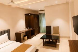 a hotel room with a bed and a desk and a table at SRS Jade Empire in Kammasandra