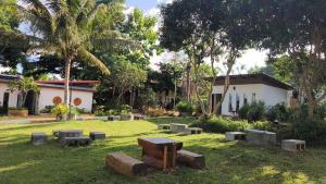 a park with benches and trees and a building at บ้านสวนร่มไม้แอ๊ดเชียงดาว in Ban Hua Thung