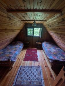 a room with two beds in a log cabin at Kremna Cottage in Kremna
