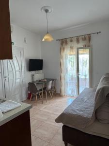 a bedroom with a bed and a table with chairs at Eleana's apartments in Gouvia