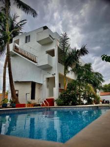 a house with a swimming pool in front of a building at Serenity beach side in Pondicherry +30 photos