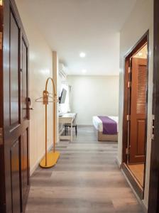 a hallway with a room with a bed and a door at Excel Hotel Bangkok former Sri Krungthep Hotel in Bangkok
