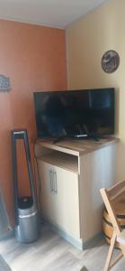 a flat screen tv on a stand with a cell phone at Far west location in Vironchaux