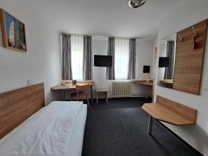 a hotel room with a bed and a desk and a table at Hotel zur Post in Weilheim an der Teck