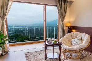 a living room with a chair and a large window at Memories Hotel in Bảo Lộc