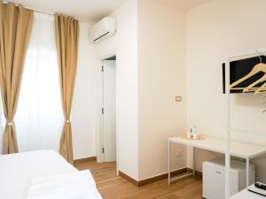 a white bedroom with a bed and a desk at La Martina Guesthouse in Angri