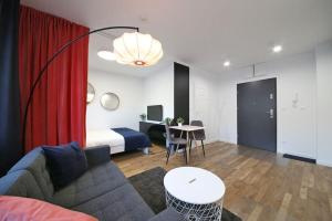 a living room with a couch and a bed and a table at A very cozy apartment with a large bed in Wrocław