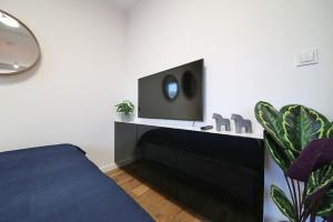 a bedroom with a bed and a tv on a wall at A very cozy apartment with a large bed in Wrocław