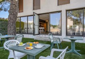 a table and chairs with food on it on a patio at B&B HOTEL Nîmes Ville Active 3 étoiles in Nîmes
