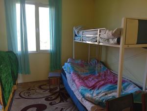 a small room with a bunk bed and a window at Sam hostel in Kochkorka
