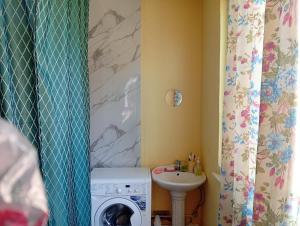 a bathroom with a washing machine and a sink at Sam hostel in Kochkorka