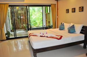 a bedroom with a large bed with a large window at Oopkaew Resort in Pua