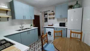 a kitchen with blue cabinets and a table and a sink at CASA RURAL CELIA con Escape Room y desayuno in Ayna