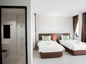 a bedroom with two beds and a bathroom at The Viewpoint Hotel in Ban Wat Tha Maprang