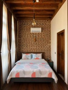 a bedroom with a large bed with a brick wall at Taş Avlu Konaklama Tesisi in Diyarbakır