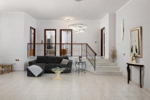 a living room with a couch and a staircase at Cielo Hillside Villa in Ialysos +17 photos
