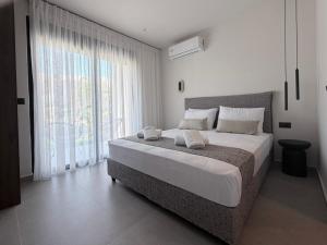 a bedroom with a large bed and a large window at Mirena Exclusive Apartments in Afantou