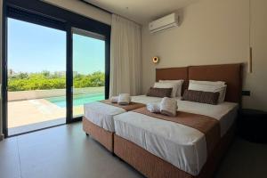 a bedroom with a large bed with a view of a pool at Mirena Exclusive Apartments in Afantou