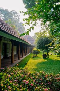 a building with a garden with flowers and trees at Indian Summer House in Mūvattupula