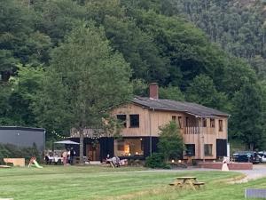 a large wooden house with a picnic table in a field at Camping Pier10 in Bourscheid