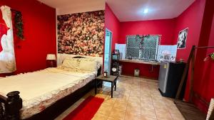 a bedroom with a bed and a red wall at Rose bungalow at Ya Nui beach in Nai Harn Beach