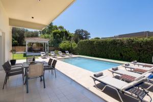 a swimming pool with chairs and a table next to a pool at Cielo Hillside Villa in Ialysos