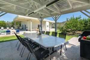 a table and chairs under a patio umbrella at Cielo Hillside Villa in Ialysos