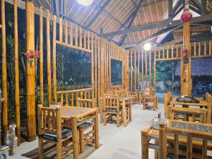 a dining room with wooden tables and chairs at Loboc Cool River Resort in Loboc